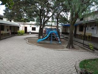 Shaded Safe House courtyard with a children's slide
